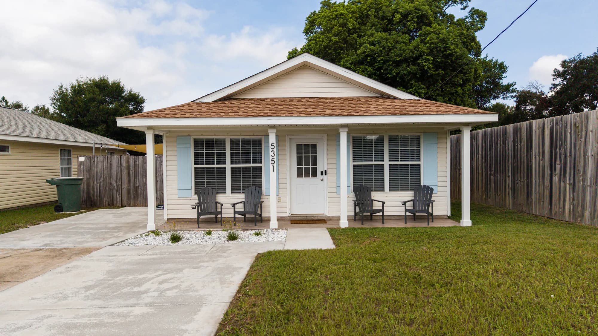 Covered front porch and pale blue shutters at the Tiny Tides cottage